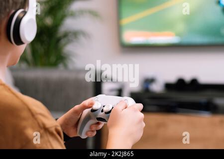 Nahaufnahme der Hände eines Jungen, der den Joystick hält. Konzept des Spielens auf der Konsole. Stockfoto