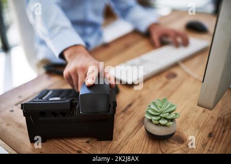 Wenn der Erfolg anruft, nehmen Sie das Telefon entgegen. Ausgeschnittene Aufnahme eines Mannes, der den Empfänger eines Telefons bei der Arbeit hält. Stockfoto