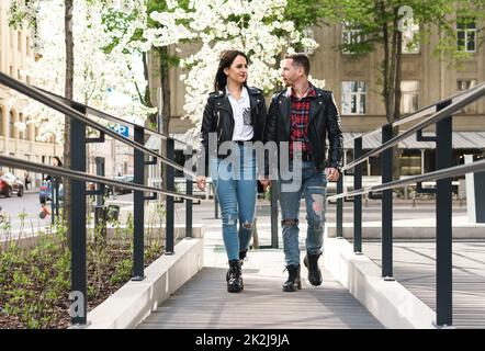 Ein wunderschönes Paar, das während seines Dates Lederjacken trägt und auf einer Straße spaziert. Stockfoto