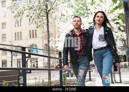 Ein wunderschönes Paar, das während seines Dates Lederjacken trägt und auf einer Straße spaziert. Stockfoto