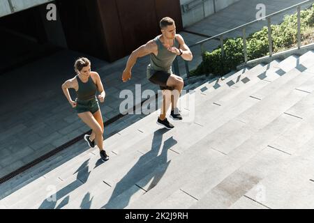 Sportliches Paar beim Training, Treppenlauf im Freien Stockfoto