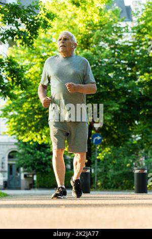 Älterer Mann während seines Jogging-Trainings in einem Stadtpark Stockfoto