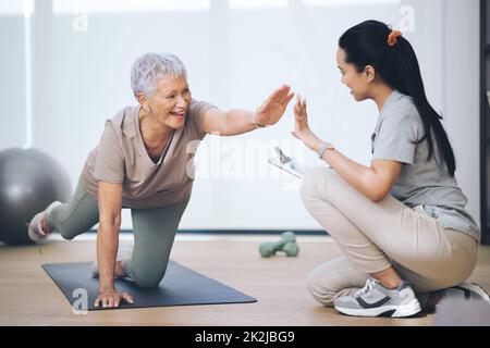 Nicht Ihre durchschnittliche Oma. Aufnahme einer älteren Frau, die während einer Sitzung mit einem Physiotherapeuten leichte Bodenübungen machte. Stockfoto