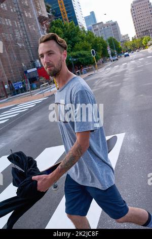 Leben am Rande. Aufnahme eines jungen Mannes, der durch die Stadt fährt. Stockfoto