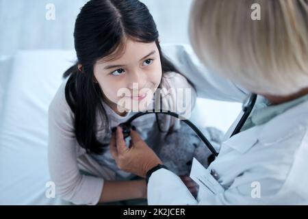 Glücklich und gesund. Aufnahme eines kleinen Mädchens, das in der Klinik eine Untersuchung erhält. Stockfoto