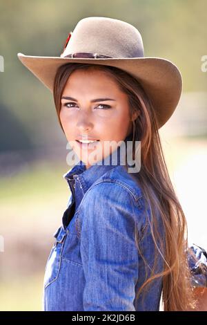 Sind Sie bereit für mich. Porträt eines attraktiven jungen Cowgirl, das in der Sonne steht. Stockfoto