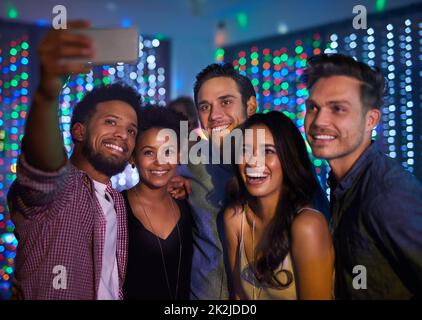 Sie haben es zu einer unvergesslichen Nacht gemacht. Ausgeschnittene Aufnahme einer Gruppe von Freunden, die während einer Party in einem Club ein Selfie gemacht haben. Stockfoto