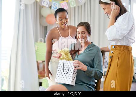 Ich liebe es, Geschenke zu empfangen. Aufnahme einer Schwangeren Mutter, die von ihren Freunden bei ihrer Babydusche Geschenke erhalten soll. Stockfoto