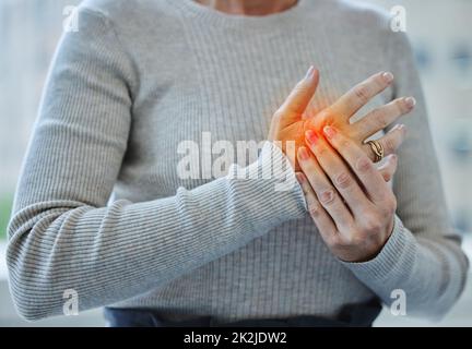 Ich habe zu lange getippt. Ausgeschnittene Aufnahme einer nicht erkennbaren Geschäftsfrau, die allein in ihrem Büro steht und unter einem Karpaltunnel leidet. Stockfoto