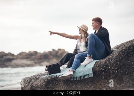 Ein Date am Strand ist alles, was es braucht, um mein Herz zu gewinnen. Aufnahme eines Mannes, der Fotos von seiner Freundin machte, während er Zeit am Strand verbrachte. Stockfoto