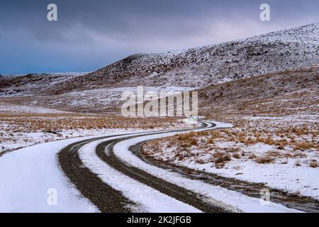 Lake Alexandrina Road im Winter, die sich durch die Hügel von Tekapo, Neuseeland, schlängelt. Stockfoto