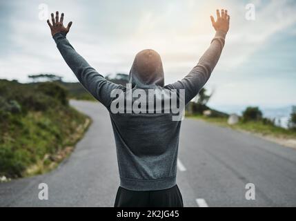 Seine Tore zu brechen. Rückansicht eines nicht erkennbaren jungen Sportlers, der draußen jubelt. Stockfoto