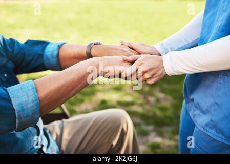 Ich helfe Ihnen, die Dinge leichter zu machen. Zugeschnittenes Bild einer nicht erkennbaren Frau, die die Hände eines älteren mannes hält. Stockfoto