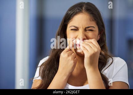 Unerwünschte Haare loszuwerden, kann schmerzhaft sein. Aufnahme einer attraktiven jungen Frau, die sich in ihrem Badezimmer fertig macht. Stockfoto