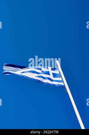 Stolz Auf Griechisch. Unterer Winkel der griechischen Flagge, die tagsüber auf sich allein gestellt steht. Stockfoto