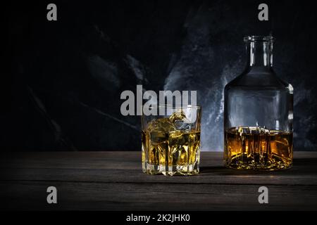 Karaffe und Glas Whisky mit Eis Stockfoto