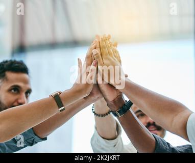 Wir haben es gemacht. Aufnahme einer Gruppe von Mitarbeitern, die sich gegenseitig hoch fiving. Stockfoto