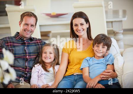 Umgeben von Liebe ohne Grenzen. Porträt einer glücklichen Familie, die sich zu Hause entspannt. Stockfoto