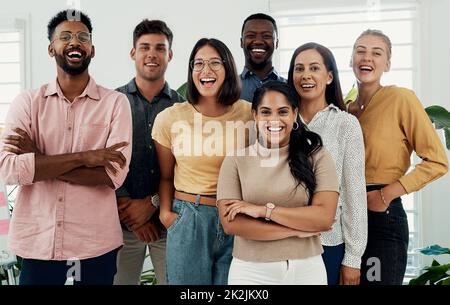 Wünschen Sie sich nicht, Sie wären Teil dieses Teams. Gekürztes Porträt eines vielseitigen Gruppengeschäfts, das nach einer erfolgreichen Diskussion im Büro zusammensteht. Stockfoto