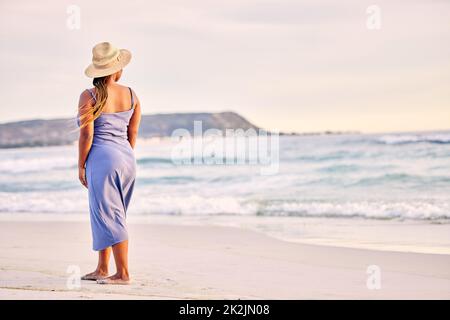 Ich blieb in Vergessenheit stecken. Rückansicht einer nicht erkennbaren Frau, die am Strand entlang läuft. Stockfoto