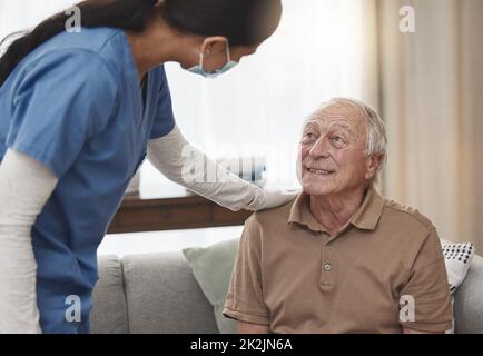 Ich bin hier für alles, was man braucht. Aufnahme einer jungen Krankenschwester, die zu Hause eine Untersuchung mit einem älteren Patienten durchgeführt hat. Stockfoto