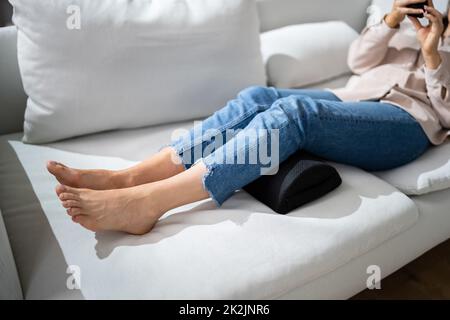 Frau, Die Fußstütze Verwendet, Um Rückenschmerzen Zu Reduzieren Stockfoto