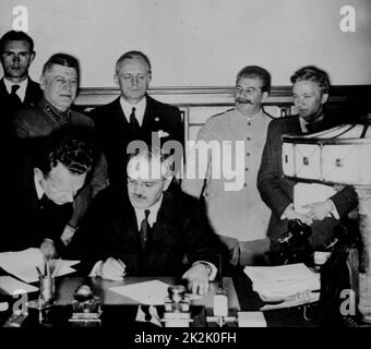 Die sowjetische Außenpolitik Commissar Wjatscheslaw Molotow Zeichen den deutsch-sowjetischen Nichtangriffspakt; Joachim von Ribbentrop und Josef Stalin stand hinter ihm. Moskau, den 23. August. 1939. Weltkrieg II. Stockfoto