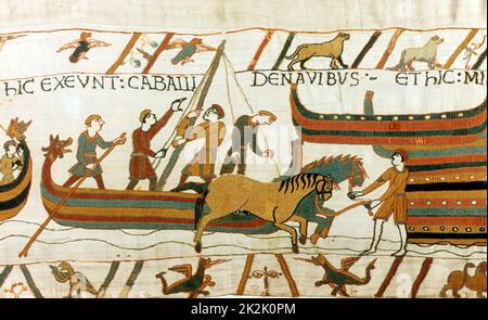 Bayeux Tapestry 1067: Pferde werden von normannischen Booten in Pevensey, Südküste Englands, 28. September 1066 entladen. Schlacht von Hastings zwischen Wilhelm von der Normandie und Harold von England, 14. Oktober 1066. Invasion Textile Leinenwäsche Stockfoto