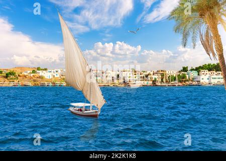 Segelboote im Nil vor traditionellen Gebäuden, Asuan, Ägypten Stockfoto