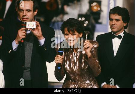 Telethon 1990 Charity-Abend. Der Sponsor des Abends, die Schauspielerin Claudia Cardinale, der Moderator Claude Sérillon (r.) und Frédéric Mitterrand (l.). 8. Dezember 1990 Stockfoto