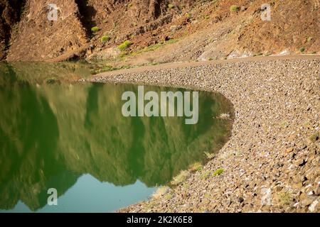 Malerischer Hatta-Damm-See mit charakteristischer Gebirgslandschaft im Hintergrund im Emirat Dubai der Vereinigten Arabischen Emirate Stockfoto