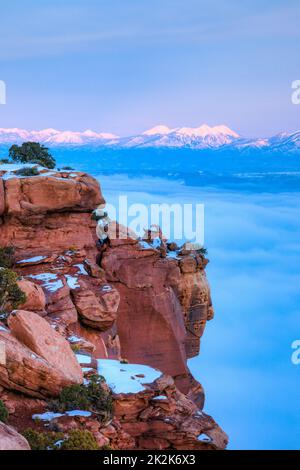 Sonnenuntergang im Winter am Grandview Point mit einem Meer von Wolken unten. Canyonlands NP. Die Berge von La Sal im Hintergrund. Stockfoto