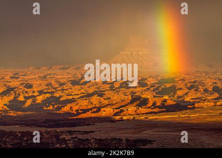 Sturm mit Regenbogen über dem Canyonlands National Park, Moab, Utah. Blick vom Buck Canyon mit Blick auf Hatch Point Mesa dahinter. Stockfoto