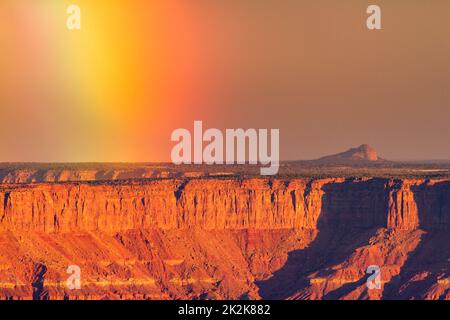 Sturm mit einem Regenbogen über Hatch Point Mesa. Blick vom Buck Canyon Overlook im Canyonlands National Park, Moab, Utah. Stockfoto