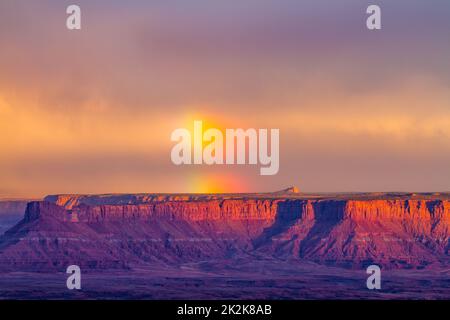 Sturm mit einem Regenbogen über Hatch Point Mesa. Blick vom Buck Canyon Overlook im Canyonlands National Park, Moab, Utah. Stockfoto