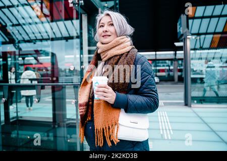 Ältere Frau wartet auf den Zug am Bahnhof Stockfoto