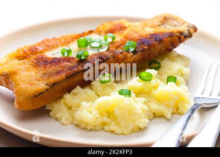 Gebratener Fisch mit Kartoffelpüree und Frühlingszwiebeln Stockfoto