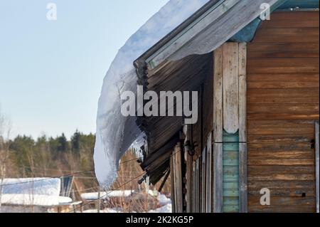 Ein Eisblock hängt vom Dach des Hauses Stockfoto