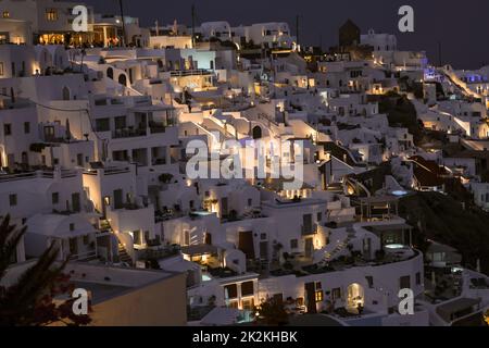 Beleuchtete, weiß getünchte Häuser mit Terrassen und Pools und einer wunderschönen Aussicht in Imerovigli auf der Insel Santorini Stockfoto