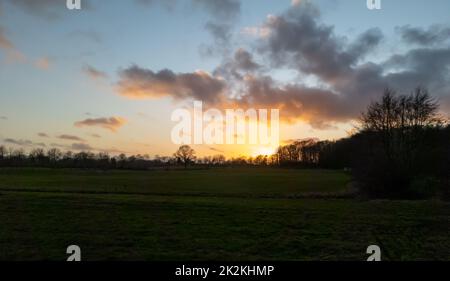 Wunderschöner und romantischer Sonnenuntergang in atemberaubenden Gelb- und Orangenfarben. Stockfoto