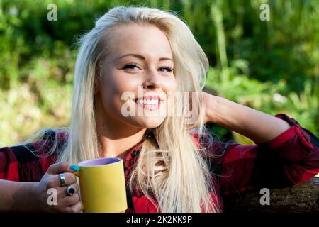 Lächelnde blonde Frau auf dem Land Stockfoto