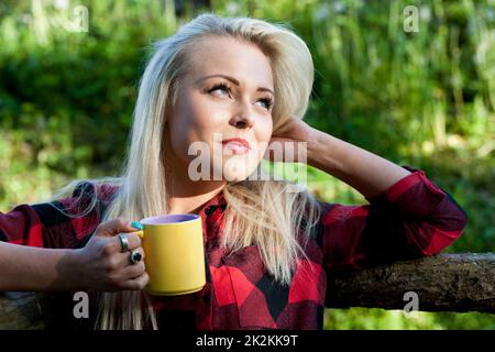 Ein hübsches, blondes Mädchen, das trinkt Stockfoto
