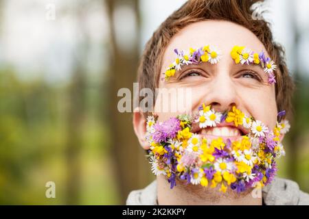 Porträt eines Mannes mit Blumen anstelle seines Barts Stockfoto