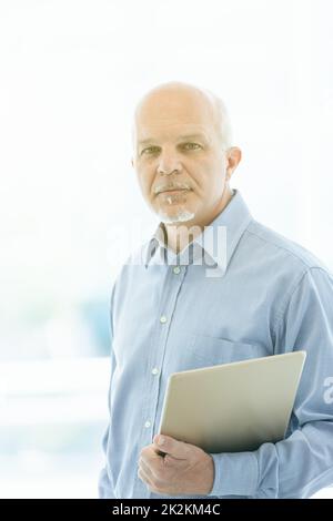 Rücksichtsvoller Geschäftsmann, der mit voller Aufmerksamkeit in die Kamera starrt Stockfoto