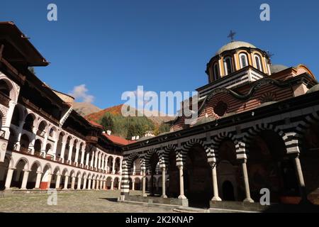 Im Inneren des Klosters Rila, die Hauptkirche vorne und der Wald hinten Stockfoto