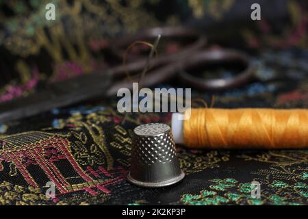 Gelbes Faden und Kaugummi auf klassischer chinesischer schwarzer Seide Stockfoto