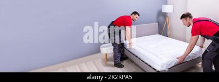 Junge Männliche Spielfiguren Legen Die Matratze Über Das Bett Stockfoto