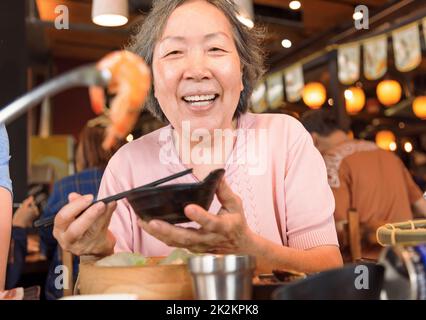 Glückliche Mutter und Familie beim Abendessen und feiern den Muttertag im Restaurant Stockfoto
