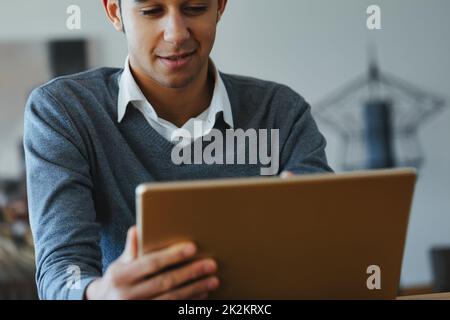 Junger Schwarzer, der Medien auf einem Tablet-pc liest oder ansieht Stockfoto