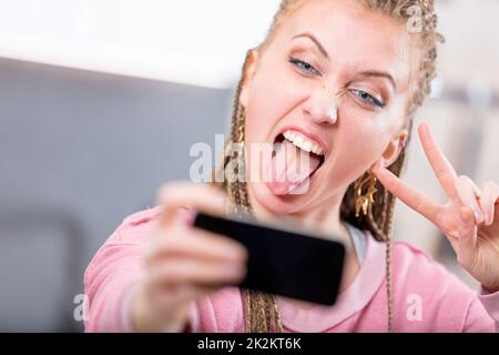 Junge Frau, die ein albernes Gesicht für ein Selfie zieht Stockfoto